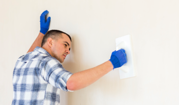 contractor-on-a-ladder-installing-structural-ceiling-panels-as-part-of-a-mitigation-and-restoration-project-miami-fl