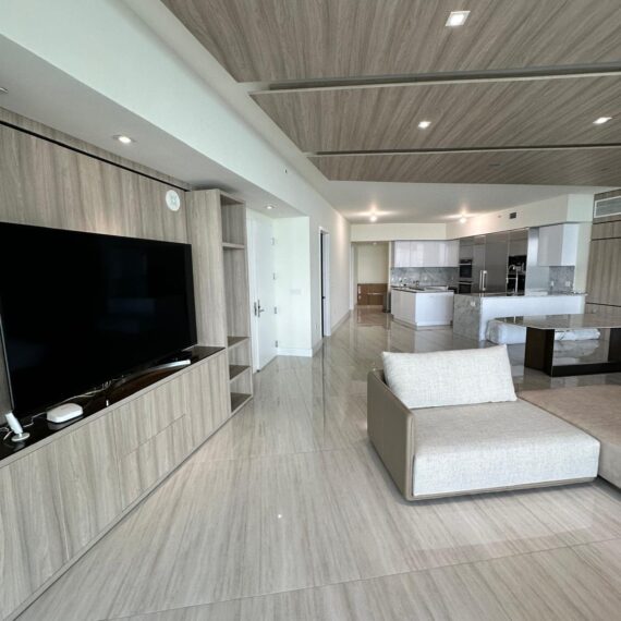 Modern living room renovation in Miami condo with custom built-ins and hardwood flooring